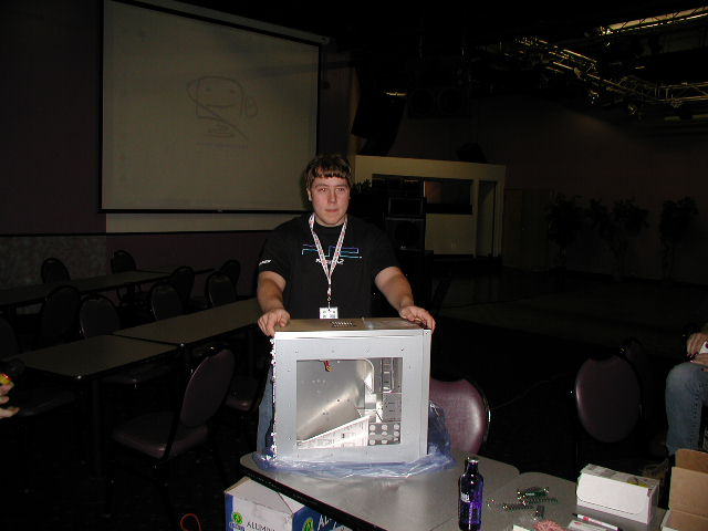 Chris stickgod Brennan standing behind computer hardware prizes at EverLAN in Boston